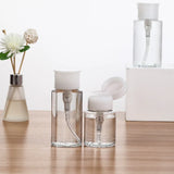 Refillable push-type dispenser bottle for nail polish and makeup remover, clear plastic container with pump nozzle.
