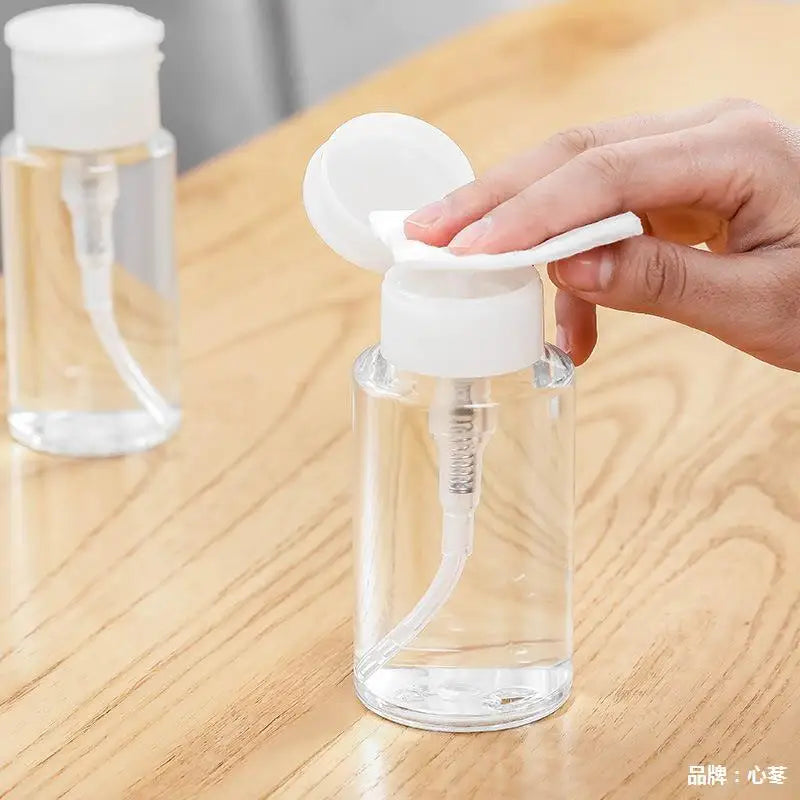 Refillable push-type dispenser bottle for nail polish and makeup remover, clear plastic container with pump for easy dispensing.